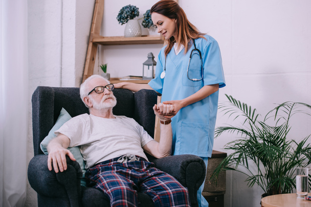 stock-photo-caregiver-supporting-holding-hand-tired-senior-man